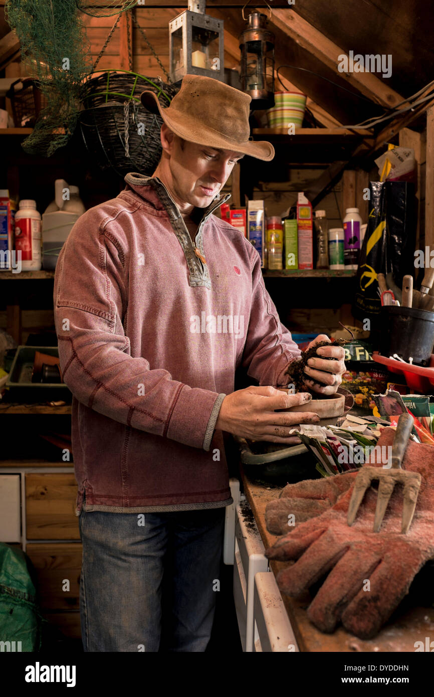 Uomo che lavora presso un banco di incapsulazione nella sua rimessa in giardino. Foto Stock