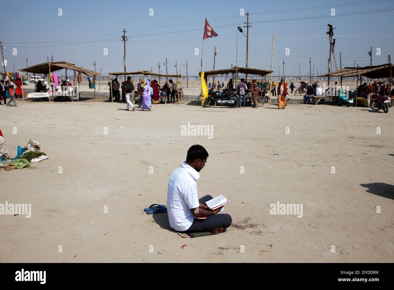 Un uomo che prega a Sangam durante il Magh Mela. Foto Stock