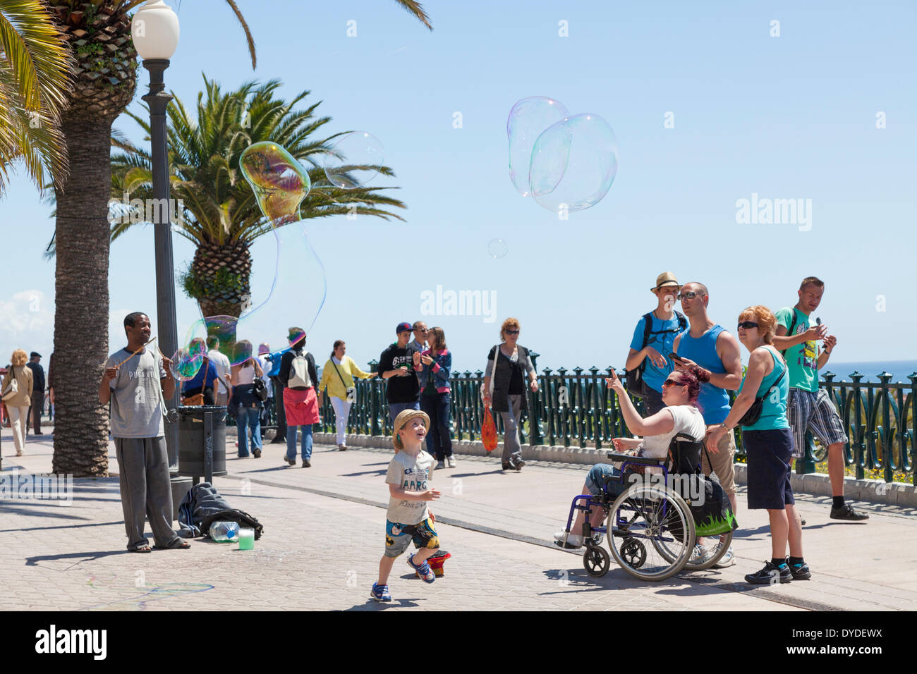 I turisti a guardare una bolla di sapone busker a Tarragona. Foto Stock
