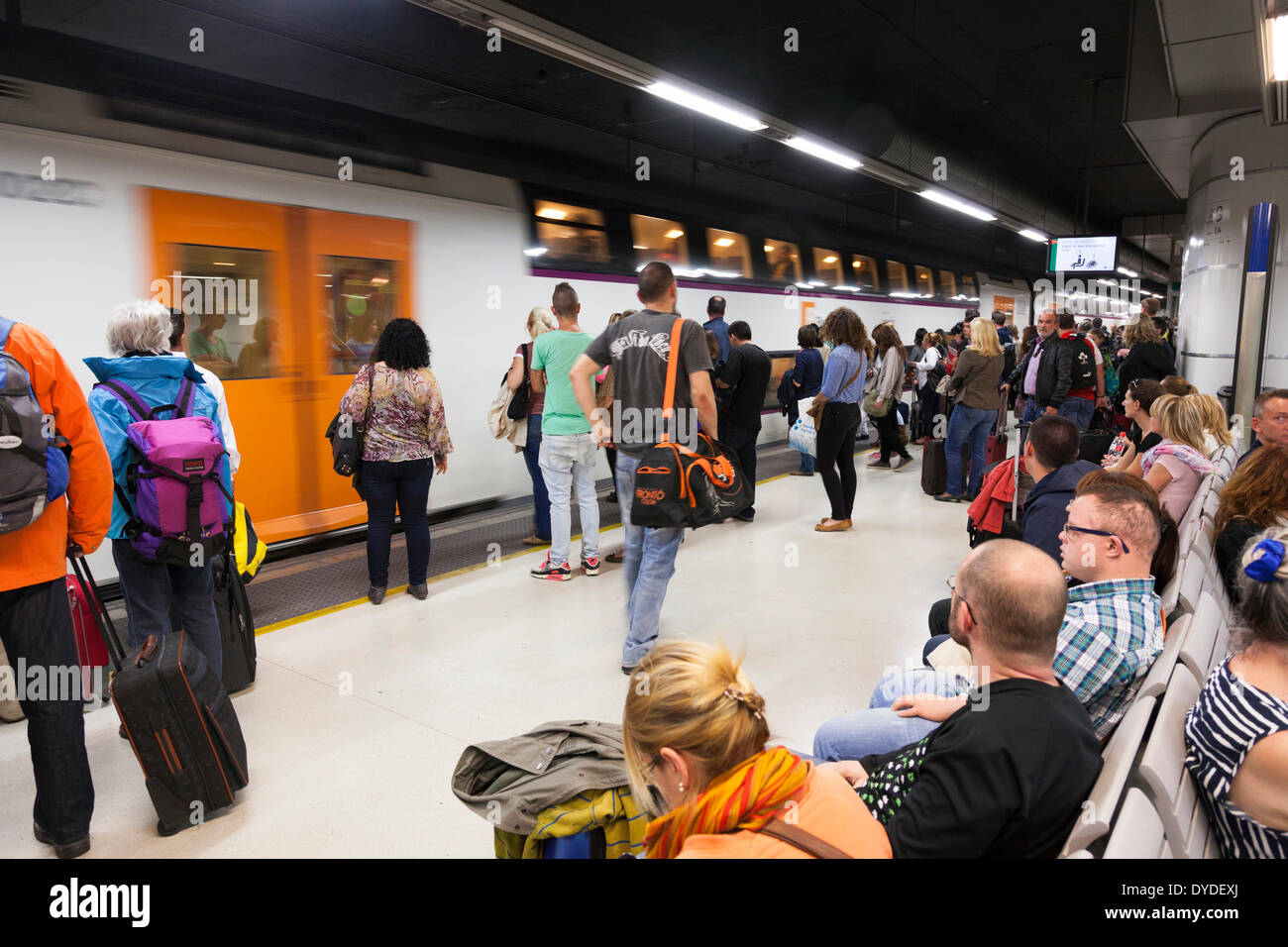 I passeggeri in attesa sulla piattaforma ferroviaria a bordo treno in arrivo. Foto Stock