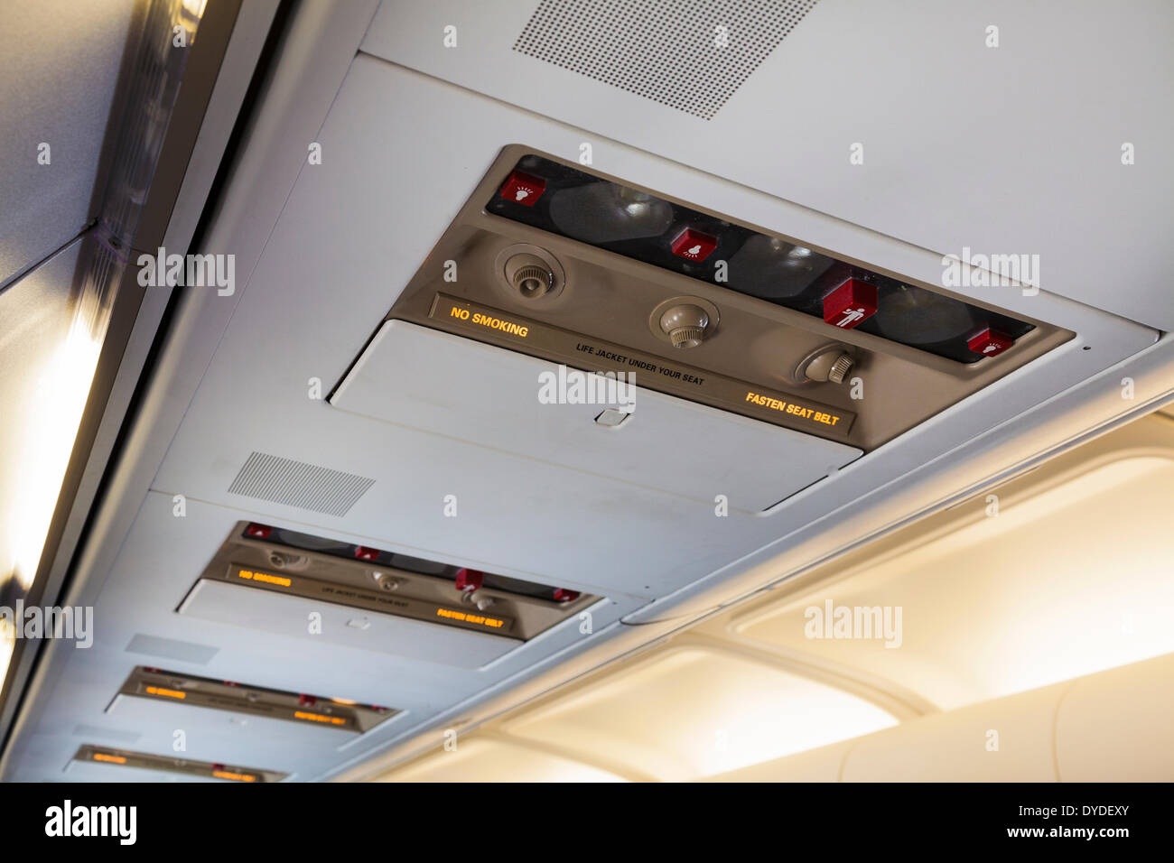 Aeroplano overhead illuminato non fumare e di allacciare le cinture di sicurezza dei segni. Foto Stock