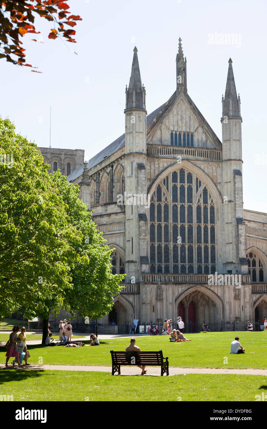 Le persone che si godono il sole estivo nella motivazione della Cattedrale di Winchester. Foto Stock