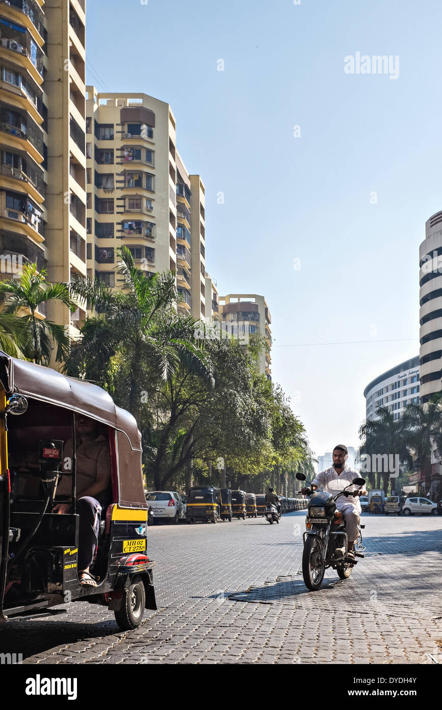 Un uomo che cavalca un motociclo indossano costumi tradizionali tra cui una preghiera musulmana cap. Foto Stock