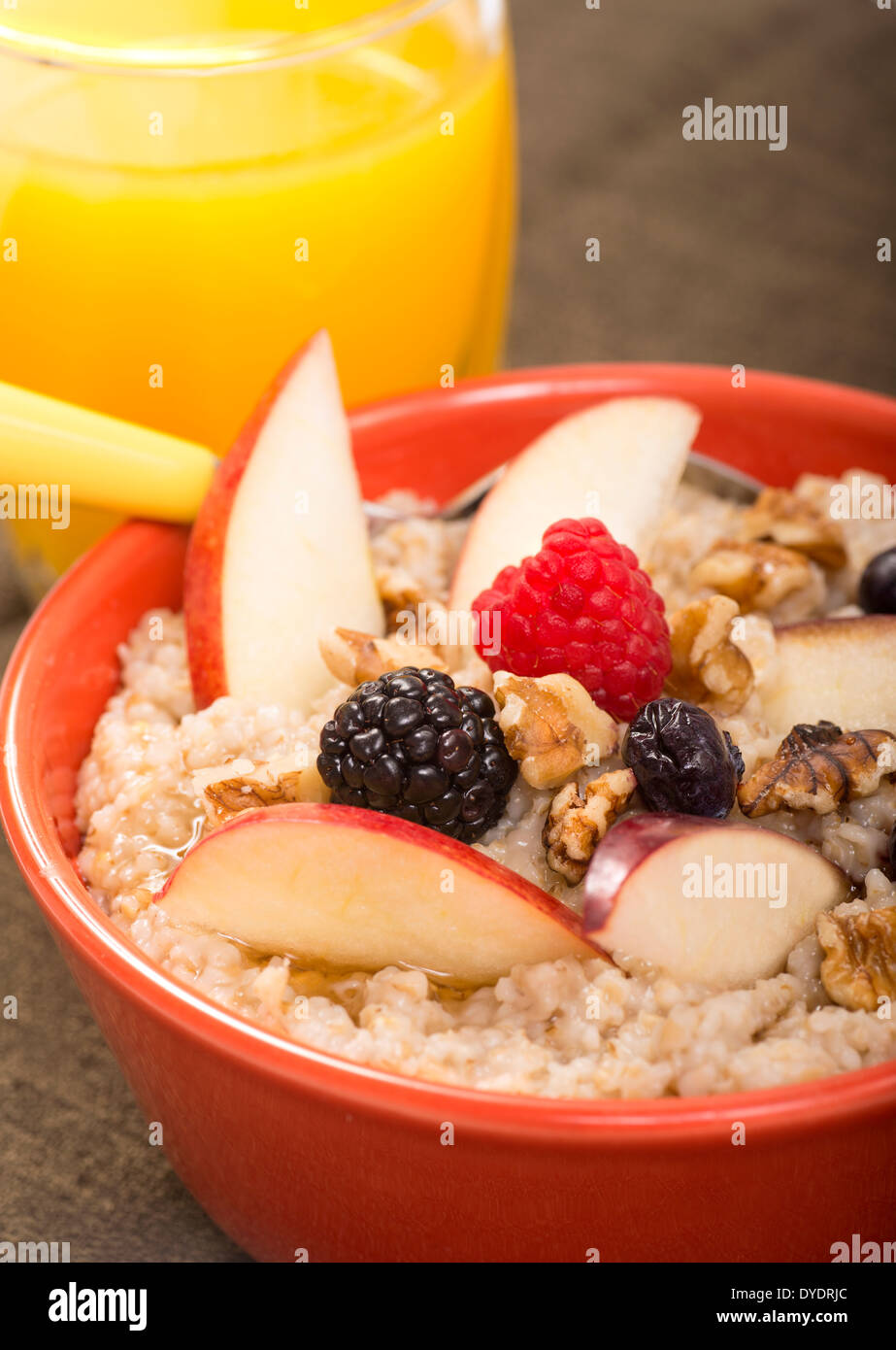 Ciotola di acciaio tagliati avena servite con frutta fresca e miele Foto Stock