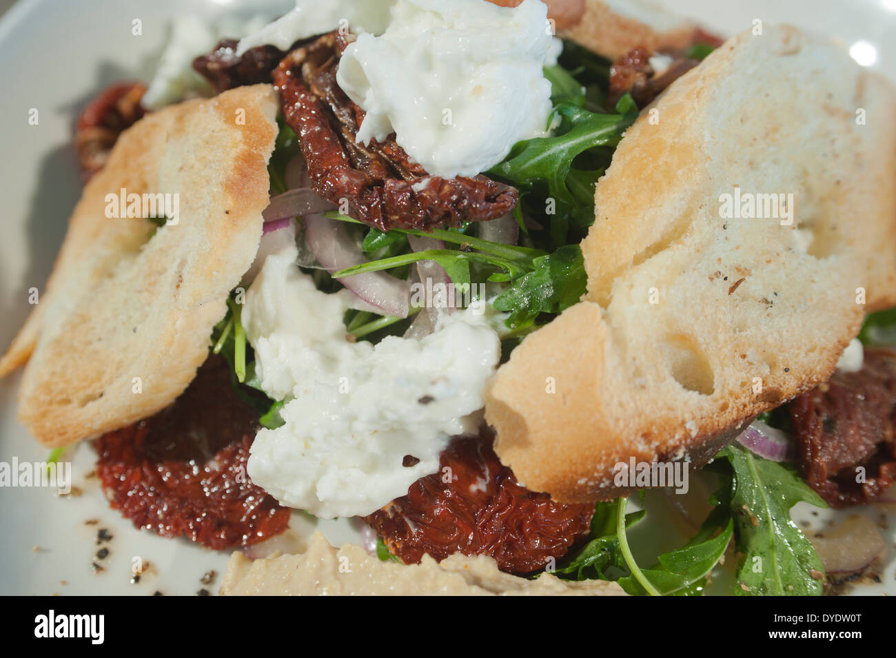 Con insalata di pomodori seccati al sole, la mozzarella, rocket (o la rucola) e pane. Foto Stock