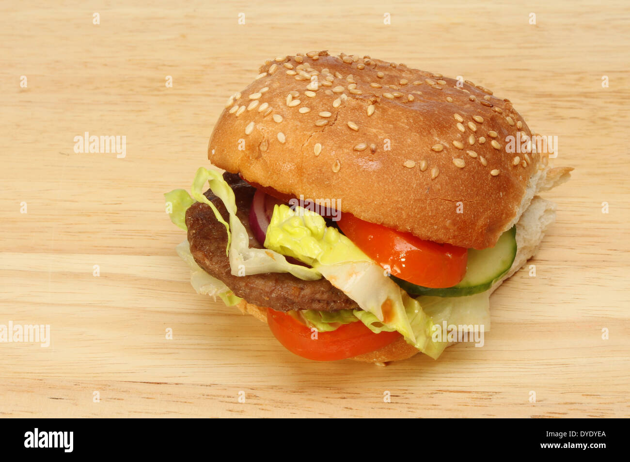 Hamburger di manzo con insalata di sesamo e seminate bap su una tavola di legno Foto Stock