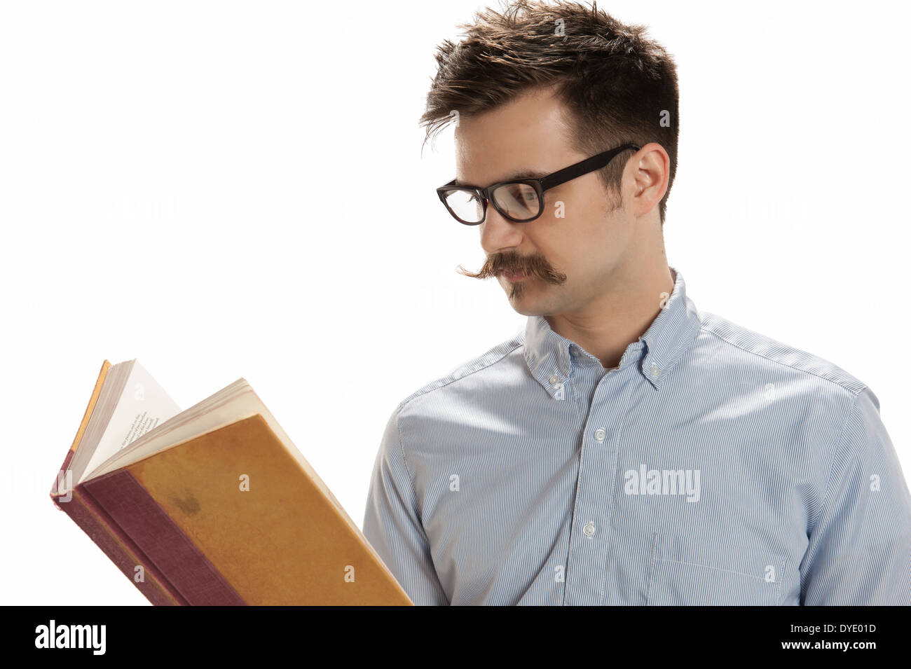 Attraente giovane con hipster occhiali e baffi manubrio legge un vecchio libro, isolati su sfondo bianco Foto Stock