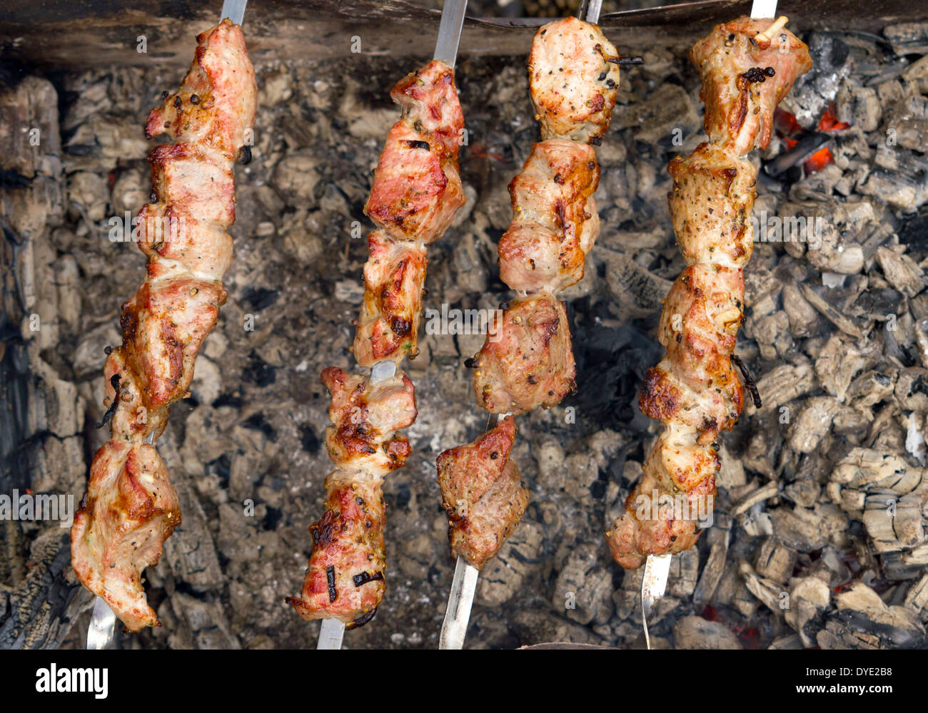 Barbecue gustoso alimento carne di maiale sulle ceneri all'aperto Foto Stock
