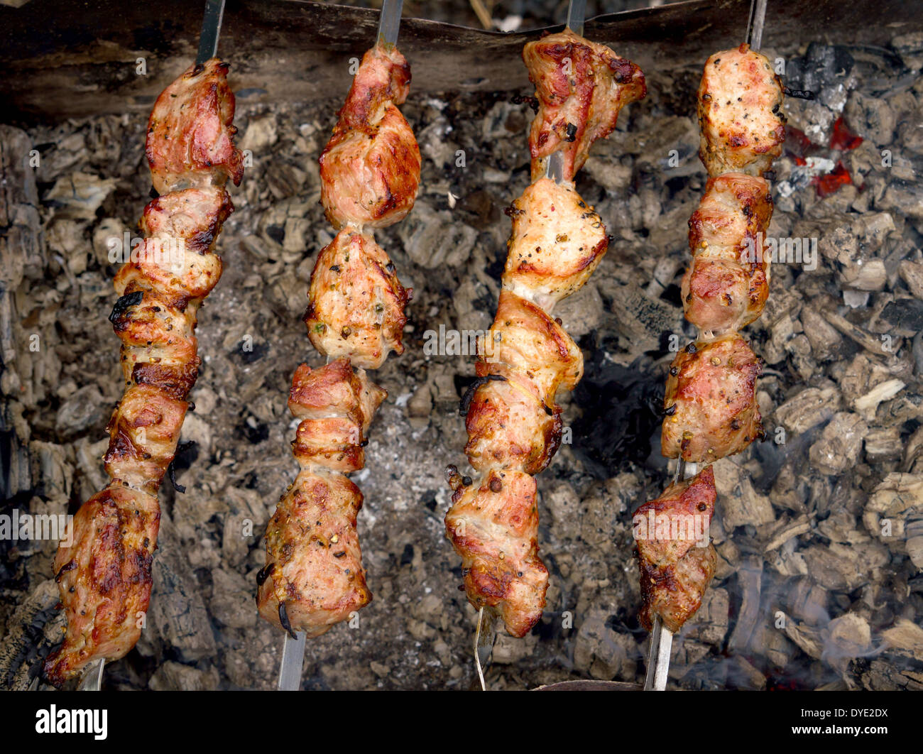 Barbecue gustoso alimento carne di maiale sulle ceneri all'aperto Foto Stock