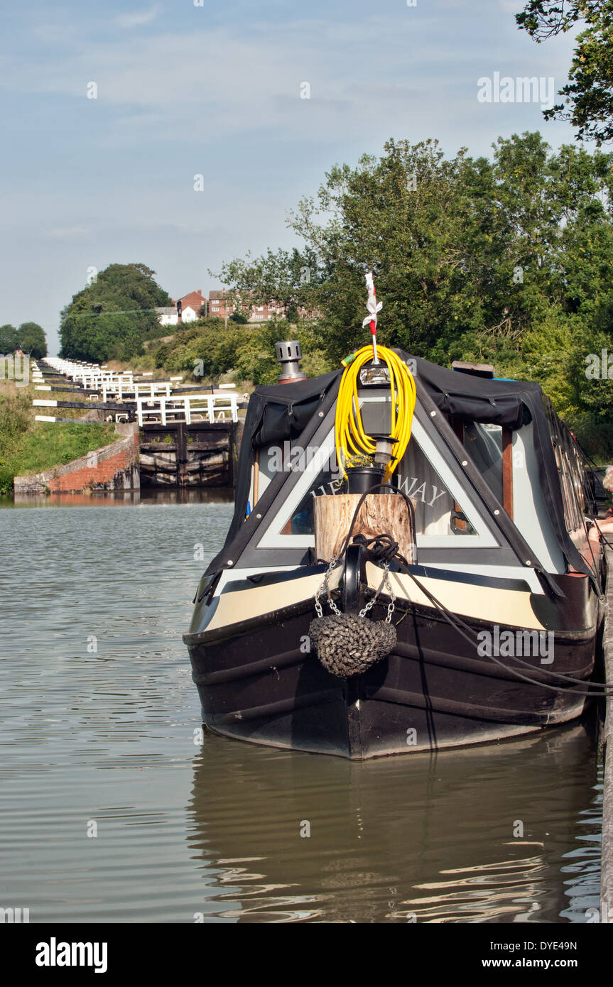 Un narrowboat ormeggiata in fondo al volo di blocchi sul Kennet & Avon canal a Caen collina vicino Devizes, Wiltshire, Regno Unito Foto Stock