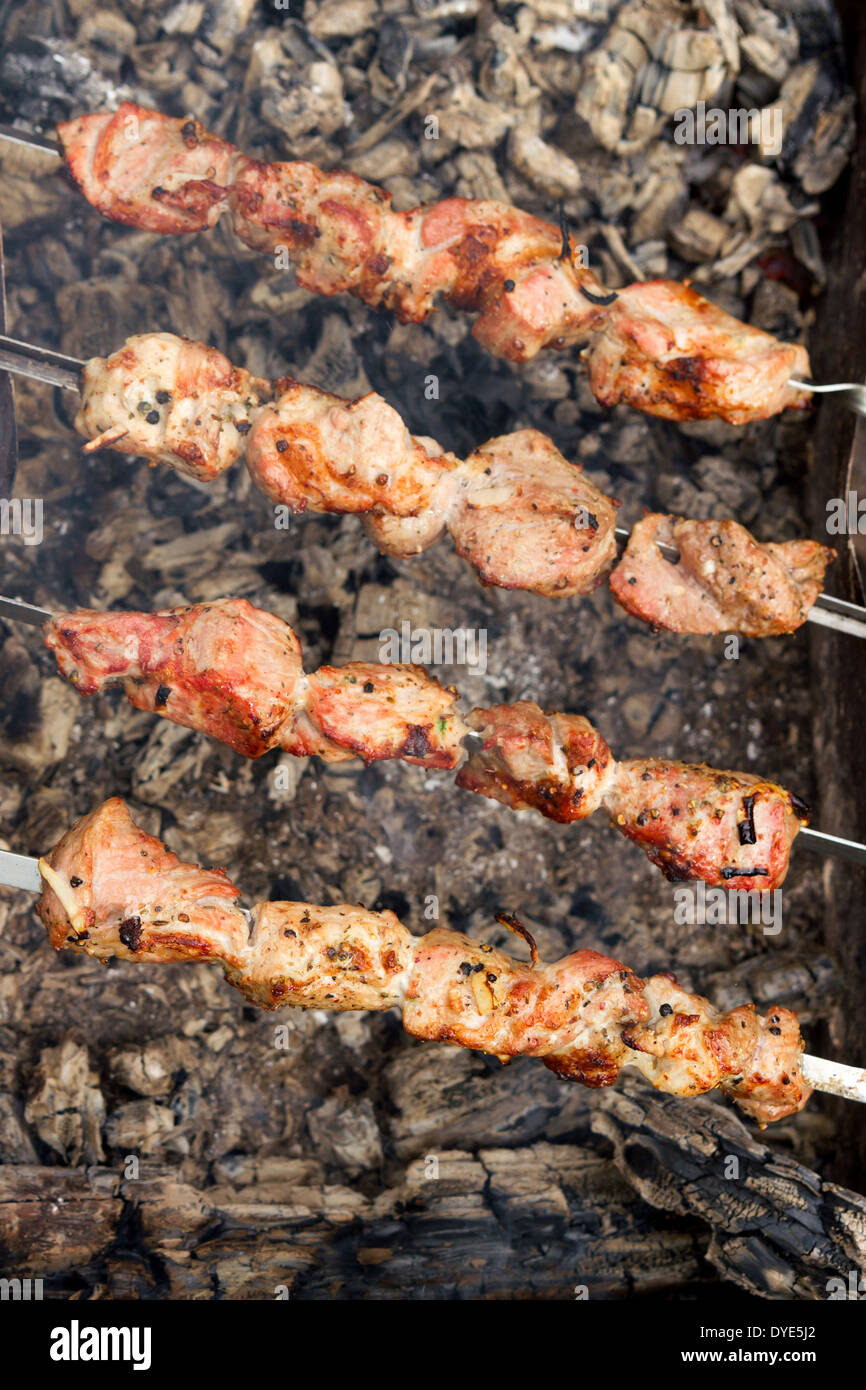 Barbecue gustoso alimento carne di maiale sulle ceneri all'aperto Foto Stock