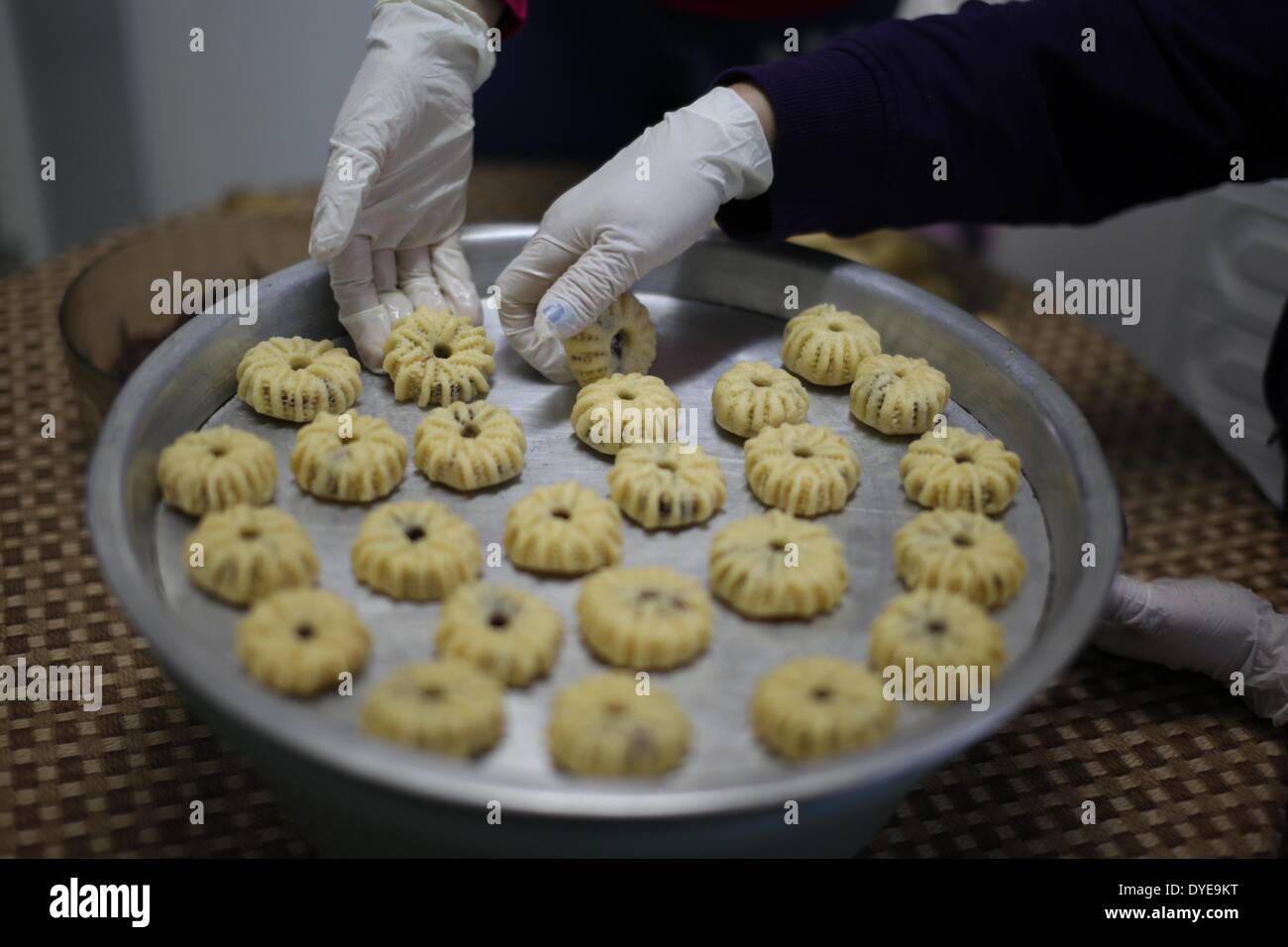 Betlemme, Betlemme. 15 apr 2014. Palestinesi cristiani preparare dolci tradizionali per le imminenti celebrazioni pasquali a casa loro in Cisgiordania città di Beit Sahour, vicino a Betlemme, il 15 aprile 2014. La Pasqua è una festa e vacanza per celebrare la risurrezione di Gesù Cristo il terzo giorno dopo la sua crocifissione sul Calvario come descritto nel Nuovo Testamento. © Luay Sababa/Xinhua/Alamy Live News Foto Stock