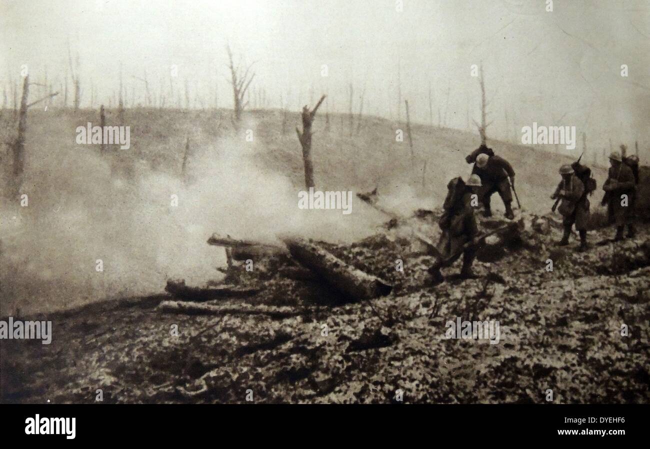 La prima guerra mondiale - soldati francesi travers un campo di battaglia contro uno sfondo di alberi distrutti dall'artiglieria. 1916 Foto Stock