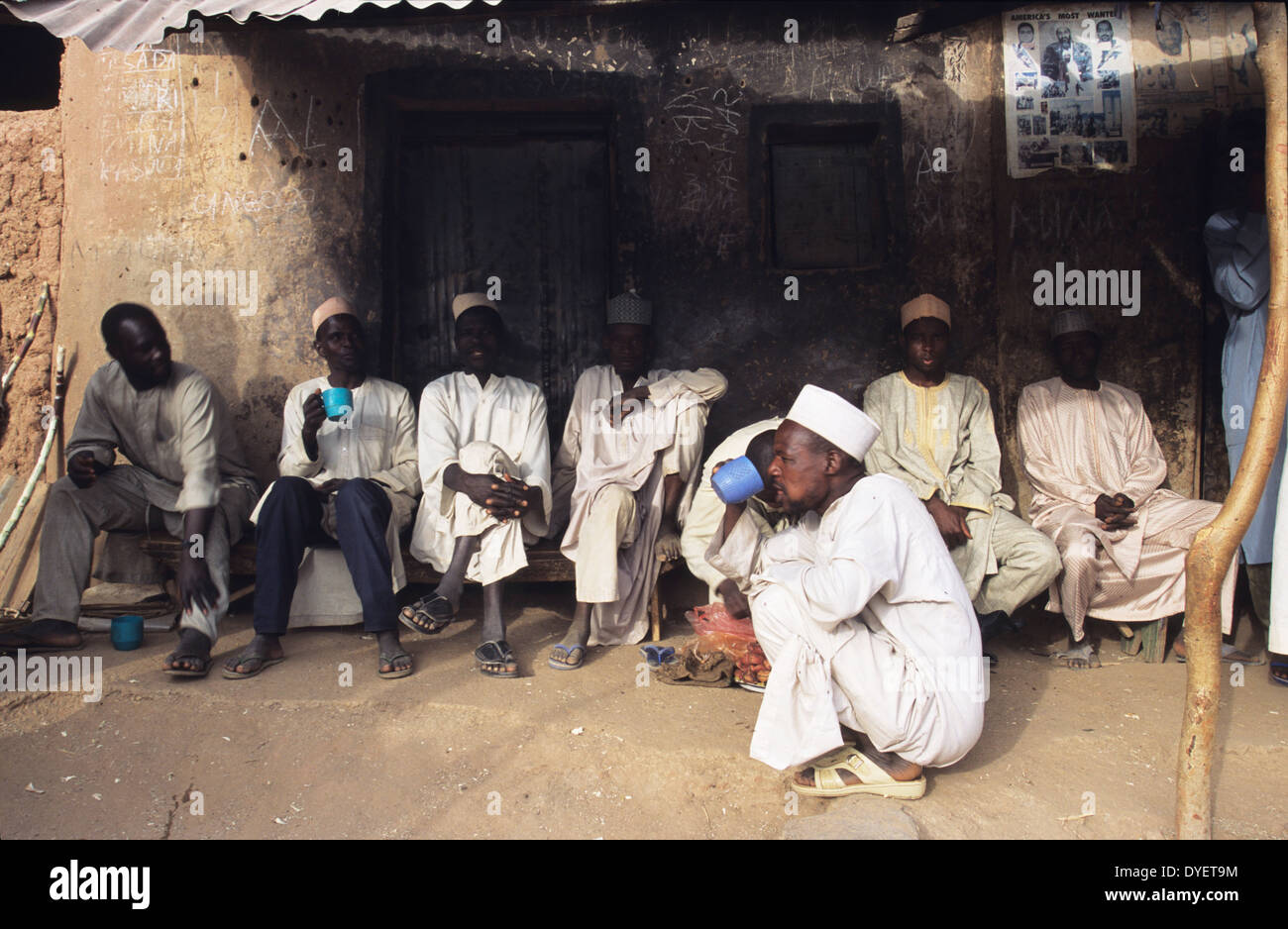 Gli uomini bere il tè. Immagini di Osama Bin Laden adornano egli strade di Kano. Kano, Nigeria Foto Stock