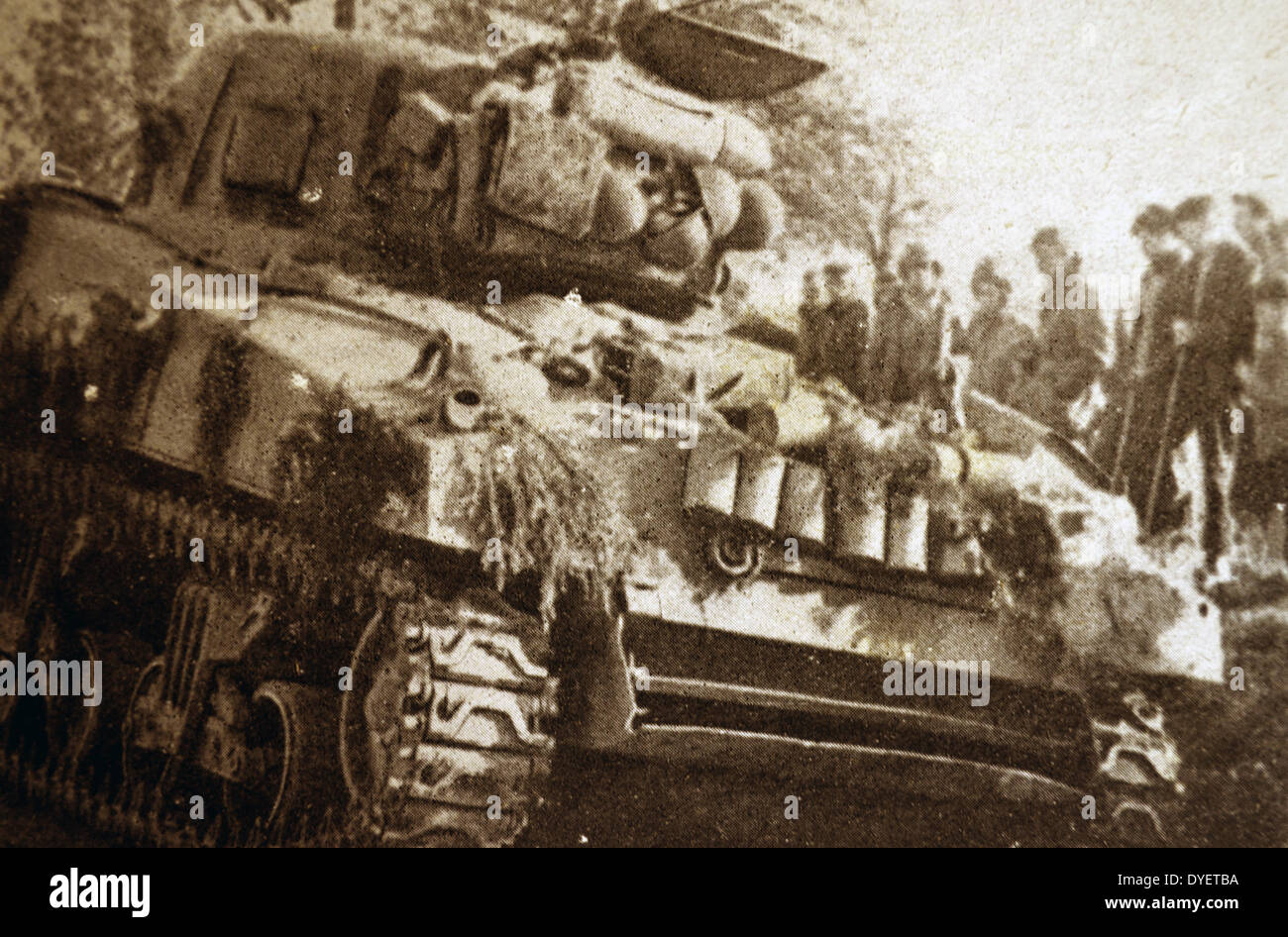 Un danneggiato tedesco serbatoio viene osservata da abitanti di un villaggio francese come l'Alsazia è liberato 1944 Foto Stock