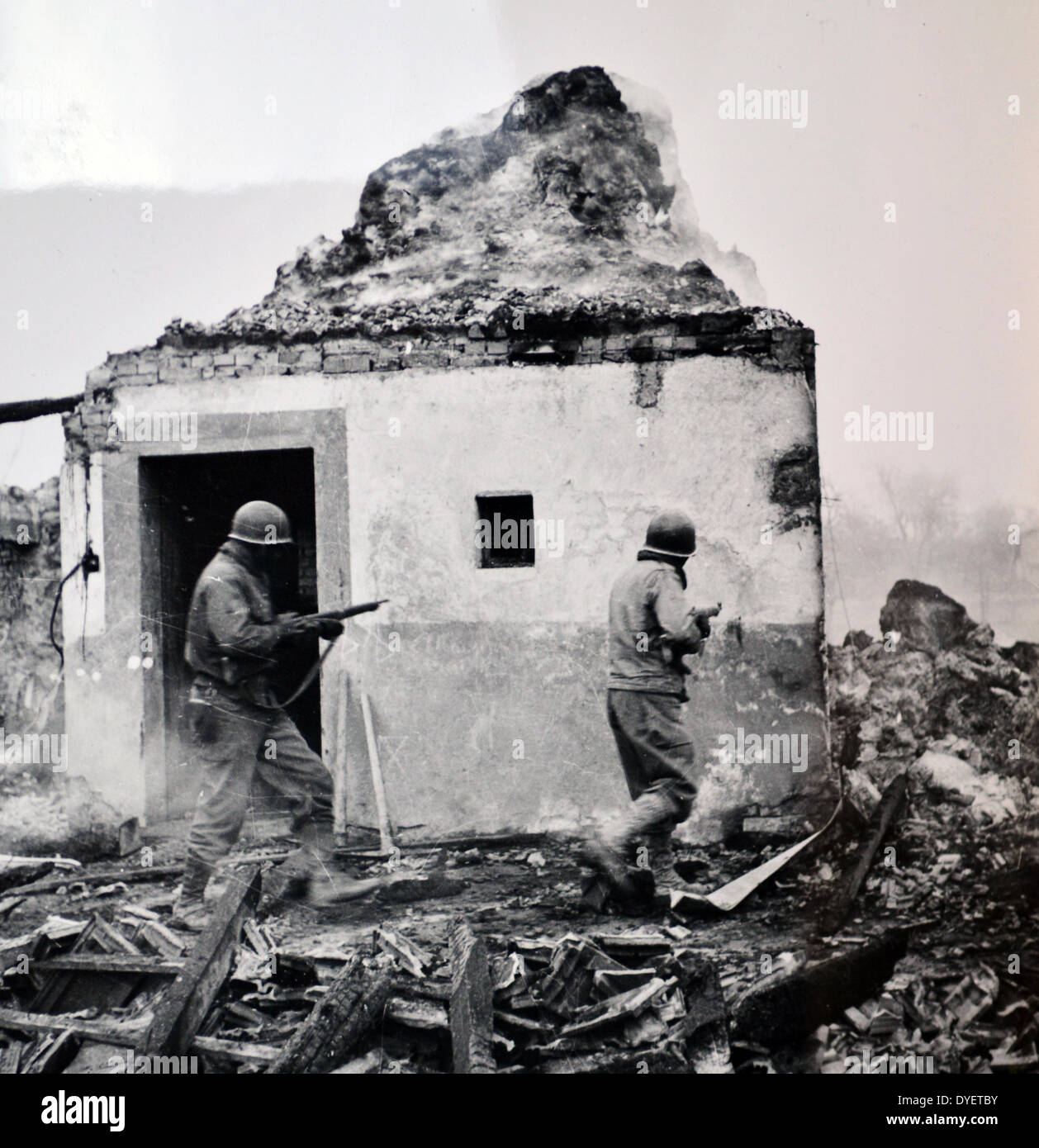 La seconda guerra mondiale: soldati americani anticipo edificio da costruire attraverso villaggi nella regione francese dell'Alsazia 1944 Foto Stock