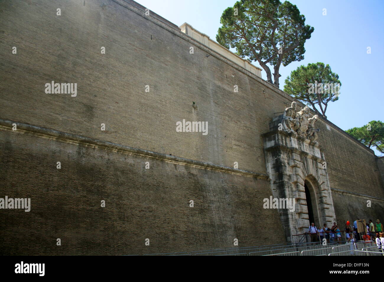 Uno dei muri attorno a Piazza San Pietro, una grande piazza che si trova di fronte alla Basilica di San Pietro in Vaticano, Italia. La parete ha una altamente decorativo entrata con il lavoro di soccorso. Foto Stock