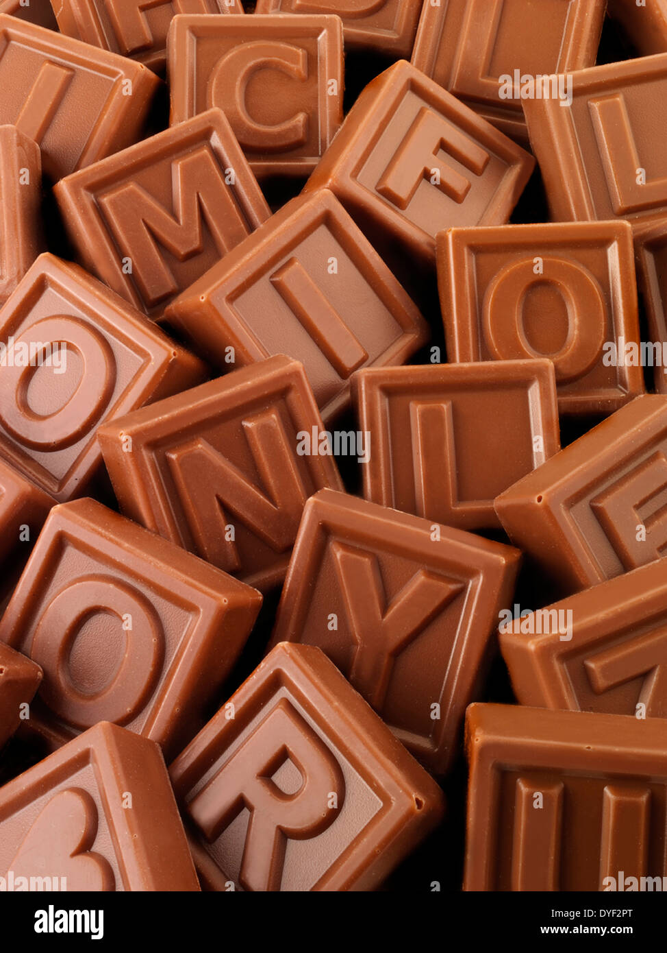 Un assortimento di quadrati di cioccolato al latte con lettere e forme su di essi Foto Stock