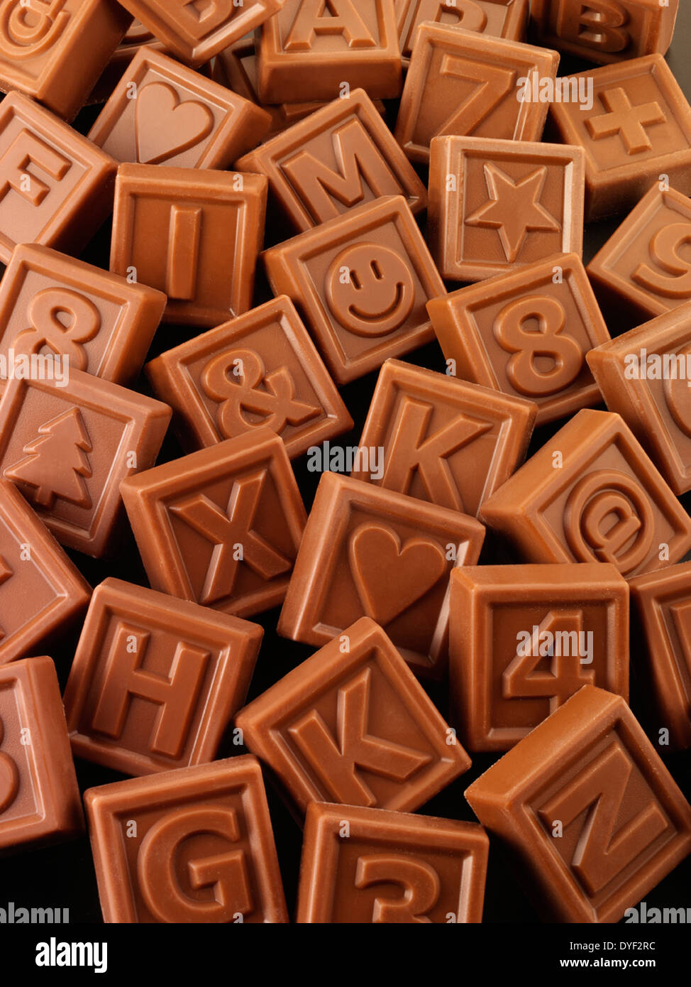 Un assortimento di quadrati di cioccolato al latte con le lettere, i numeri e le forme Foto Stock