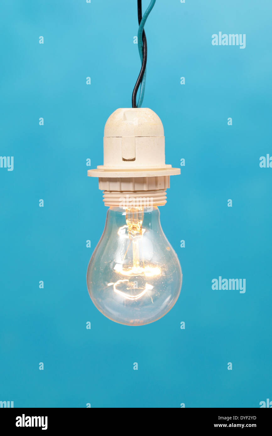 Una lampadina accesa su uno sfondo blu Foto Stock