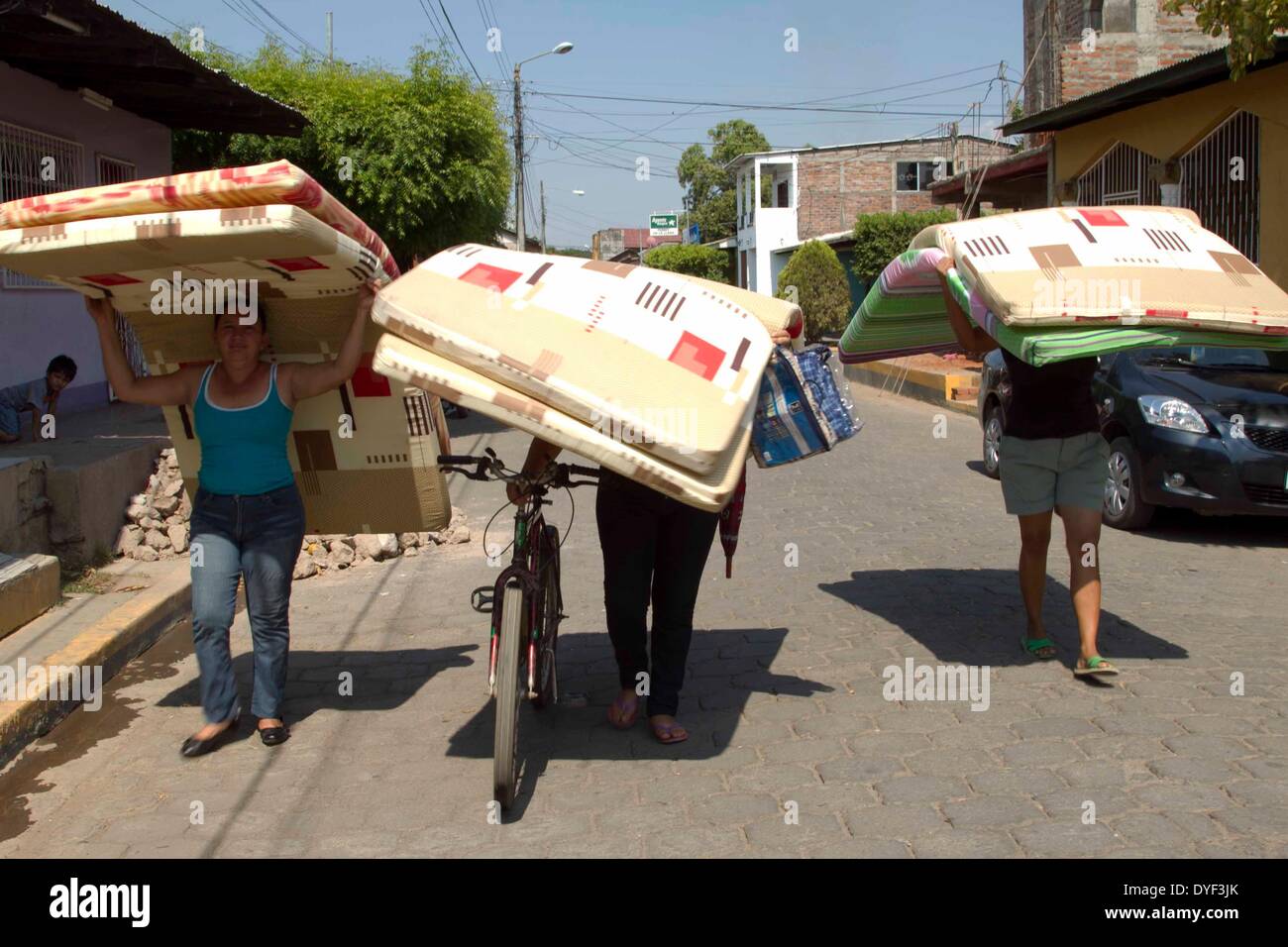 Nagarote, Nicaragua. 15 apr 2014. Le persone colpite da terremoti portare materassi dato loro in città Nagarote, del dipartimento di León, Nicaragua, il 15 aprile 2014. Il governo nicaraguense iniziata lunedì la riparazione o il miglioramento della 2,354 case colpite da ultima settimana di forti terremoti. Credito: Giovanni Bustos/Xinhua/Alamy Live News Foto Stock