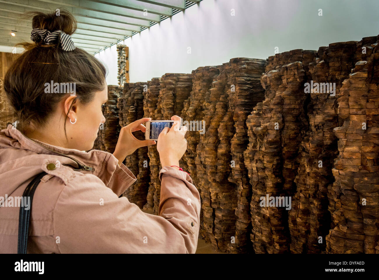 Ragazza prendendo foto su iphone di scultura di Ursula von Rydingsvard a Yorkshire Sculpture Park, Regno Unito. Foto Stock