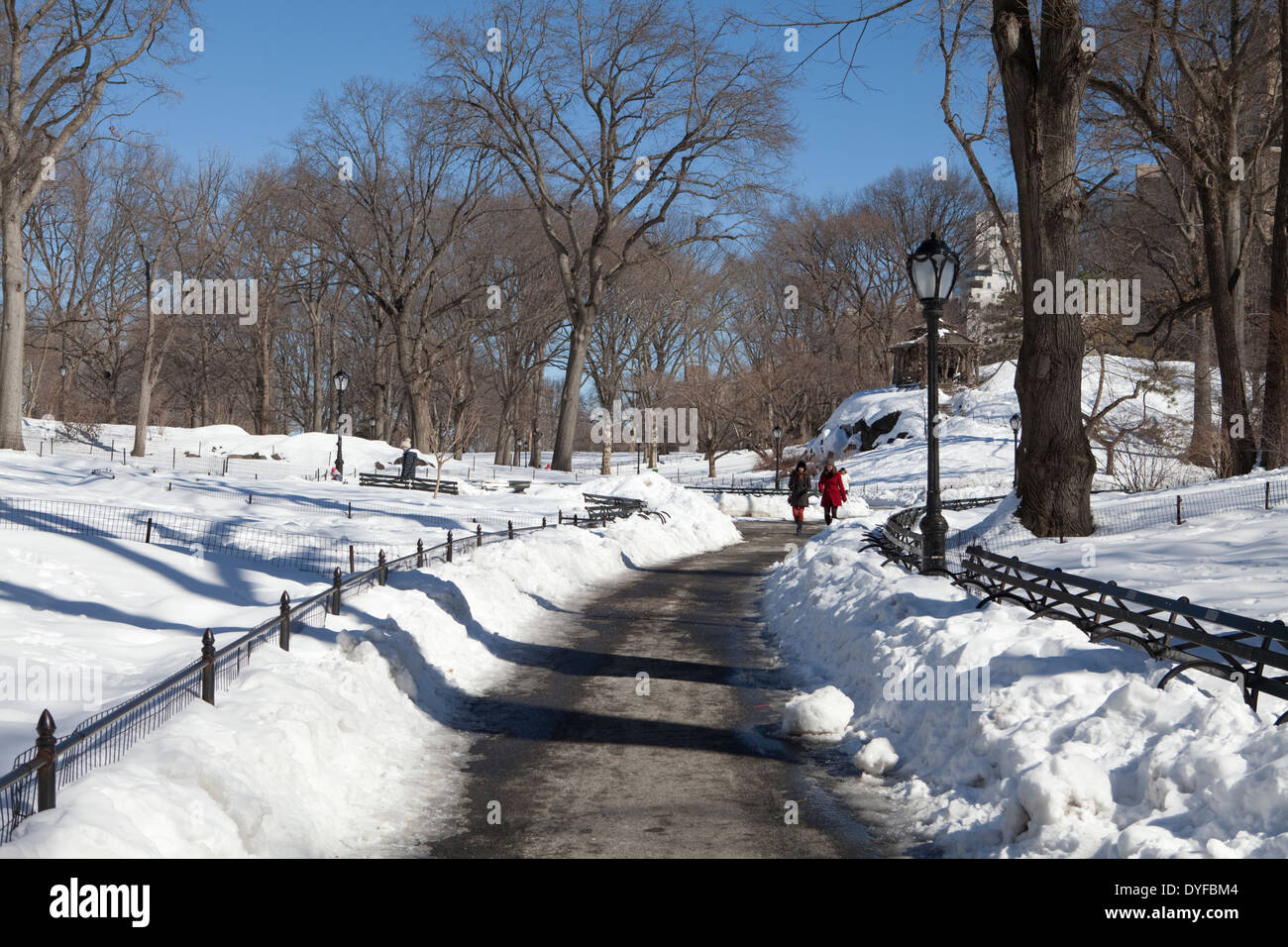 La gente camminare in una coperta di neve Central Park di New York City in una luminosa giornata invernale Foto Stock