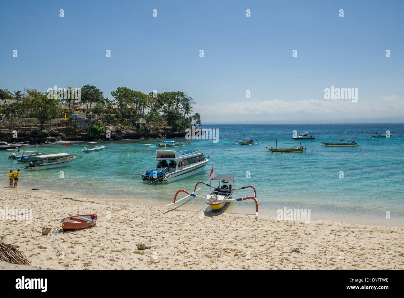 Barche in acqua e resort sulla scogliera vicino al mare blu acqua in una giornata di sole Nusa Lembongan Thailandia Foto Stock