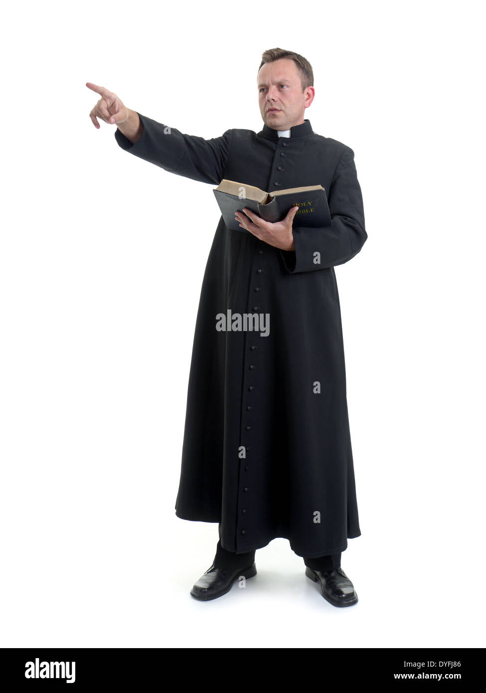 Sacerdote cattolico predicazione tenendo aperta la Bibbia prenota shot su bianco Foto Stock