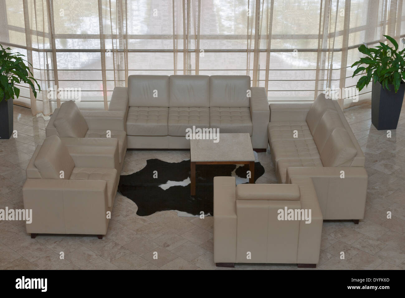 Interni beige con divani e poltrone dalla finestra panoramica Foto Stock