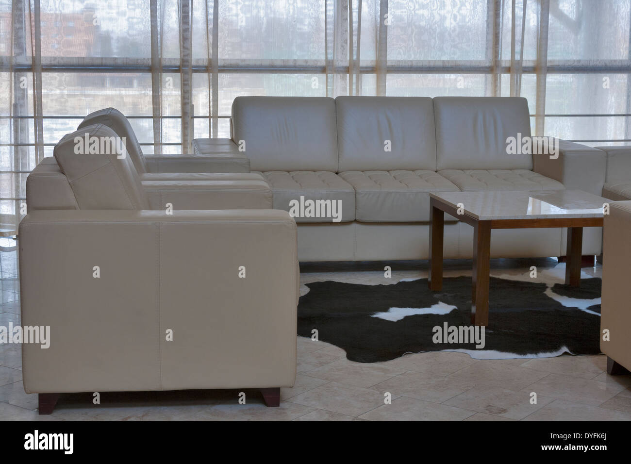 Interni beige con divani e poltrone dalla finestra panoramica Foto Stock