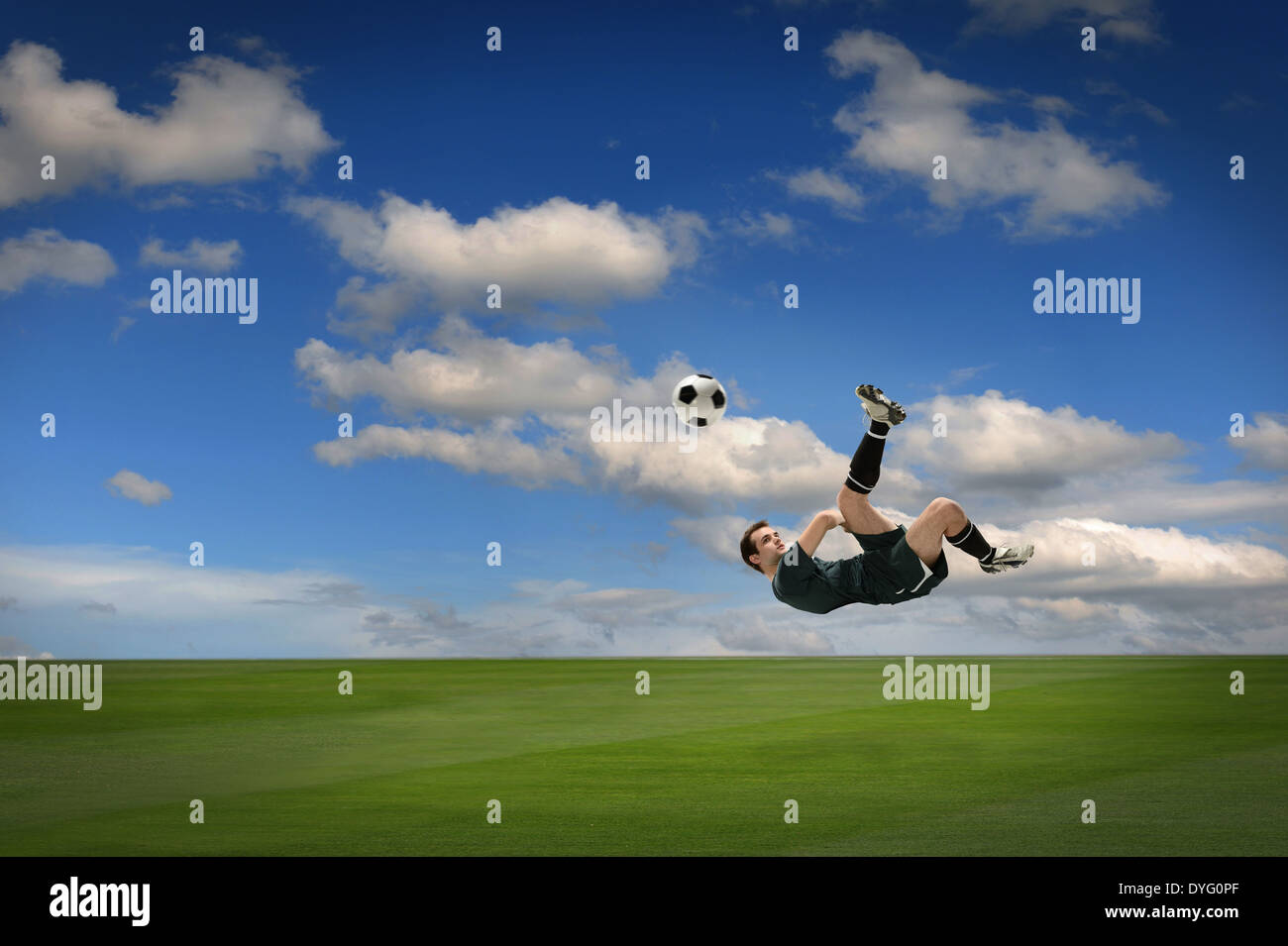 Giocatore di calcio calci palla all'aperto durante la giornata di sole Foto Stock