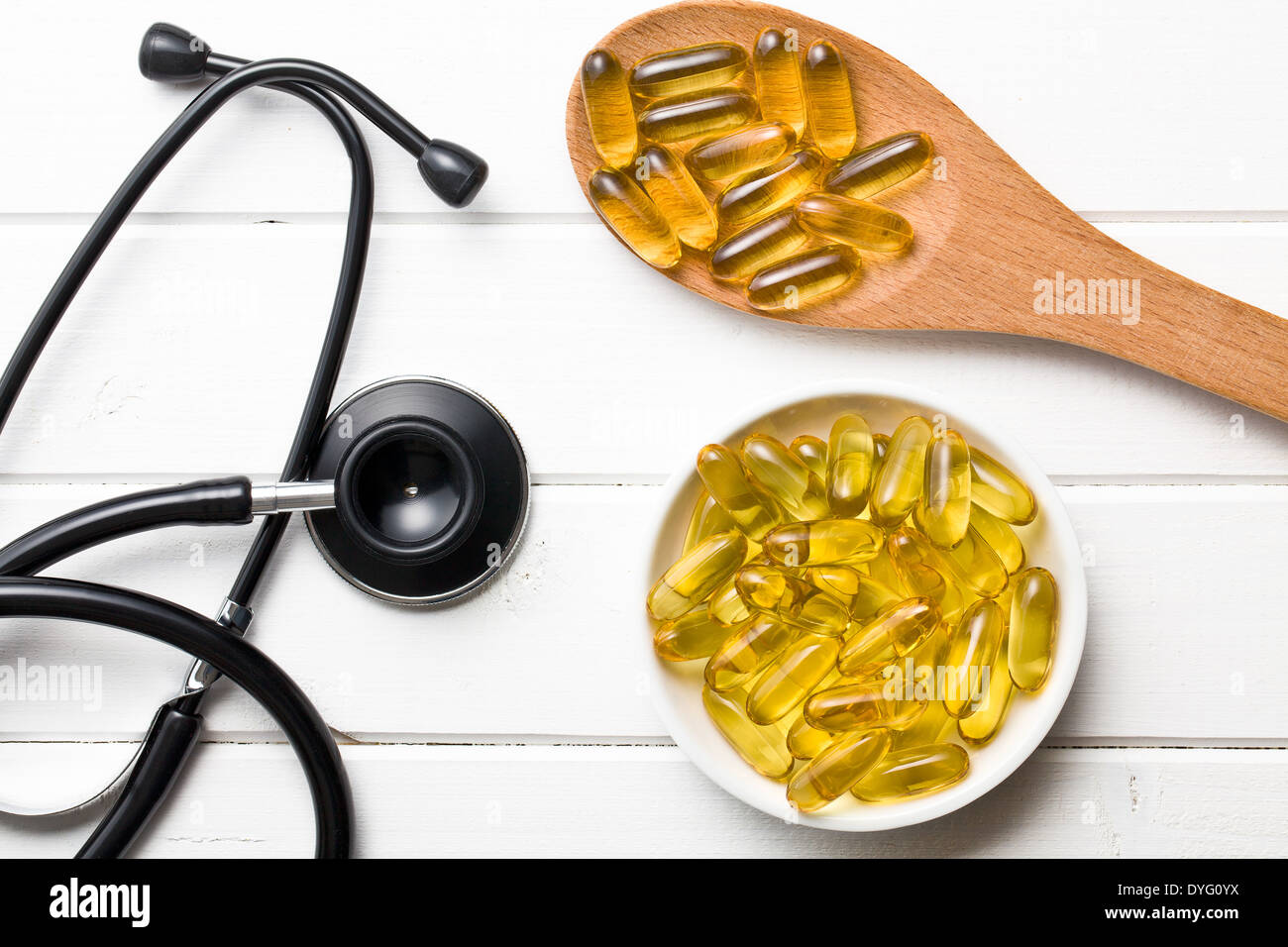 Olio di fegato di merluzzo. Le capsule di gel e uno stetoscopio Foto Stock