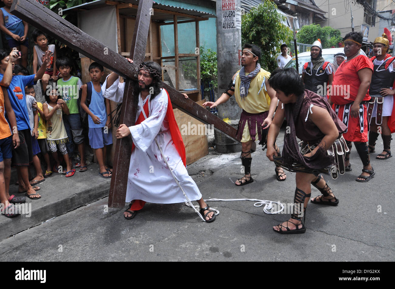 MANDALUYONG, Filippine - 17 aprile: un devoto raffigurante Cristo porta una croce di legno durante un Cenakulo o la rappresentazione della passione come parte del rispetto del Giovedì Santo riti in Mandaluyong il 17 aprile. (Foto di Jay Ganzon/Pacific Stampa) Foto Stock