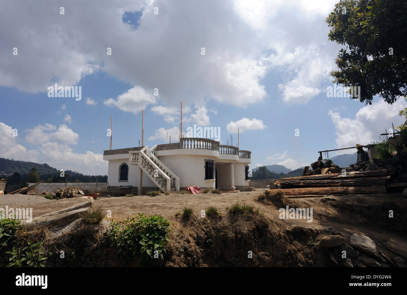 Recentemente costruita casa moderna in un villaggio delle highland. Acciaio aste di rinforzo salire dal tetto pronto per una seconda storia. Foto Stock