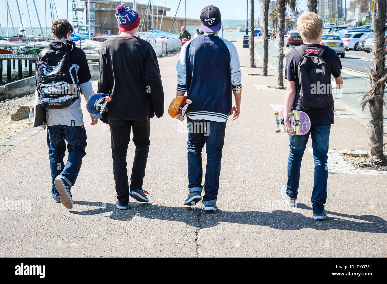 Quattro skateboarders camminando lungo il lungomare di Southend. Foto Stock