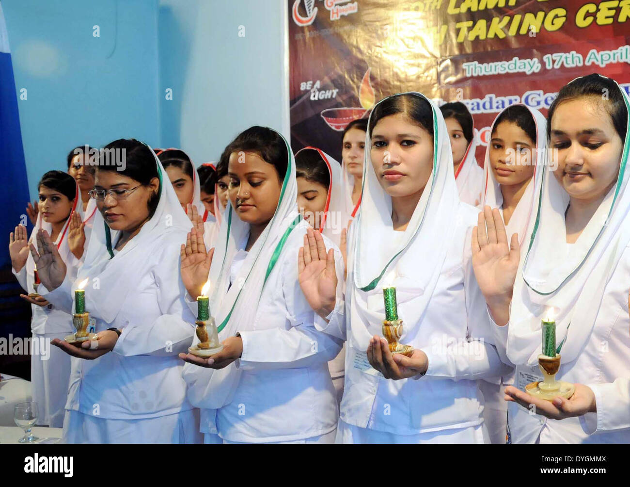 Gli infermieri di Kharadar General Hospital e Scuola tenere alleggerita candele e amministrare giuramento durante '9 lampada di illuminazione e giuramento" cerimonia tenutasi a KGH premessa a Karachi il giovedì, 17 aprile 2014. Foto Stock