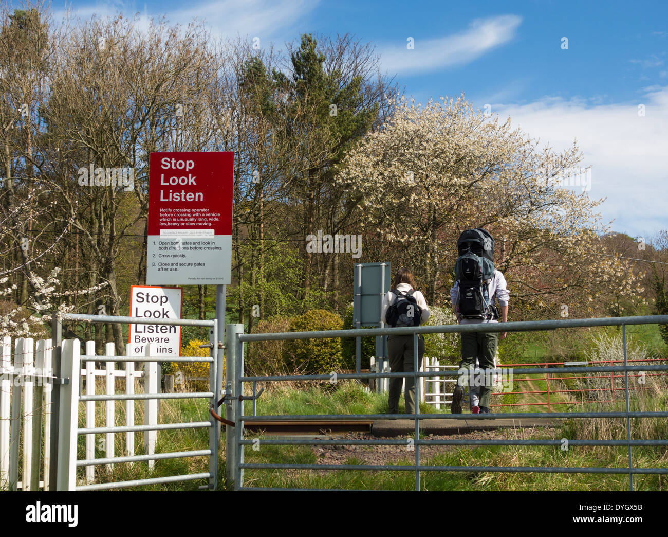 La famiglia a piedi attraversando i binari della ferrovia nei pressi di grande Ayton, North Yorkshire, Inghilterra, Regno Unito Foto Stock