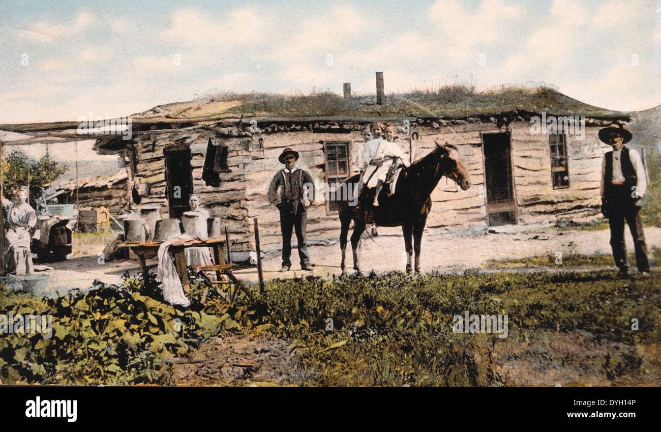 Famiglia in piedi di fronte a casa di frontiera, USA, circa 1900 Foto Stock