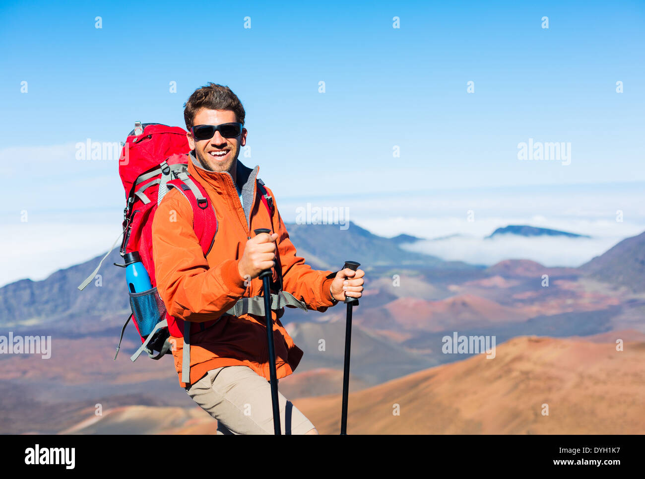 Escursionista con zaino in piedi sulla cima della montagna godendo della vista Foto Stock