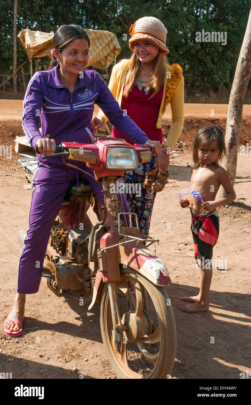 Giovani donne cambogiane al di fuori di una piccola città di salone di bellezza che condivide la sua sede con un motore garage nella provincia di Ratanakiri Foto Stock