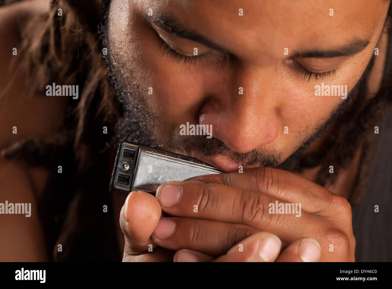 Rastafarian Man Riproduci armonica a bocca Foto Stock