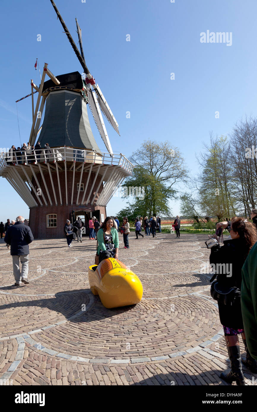 Tourist in posa di una scarpa in legno nella parte anteriore di un mulino a vento in Keukenhof in Lisse, Olanda Foto Stock