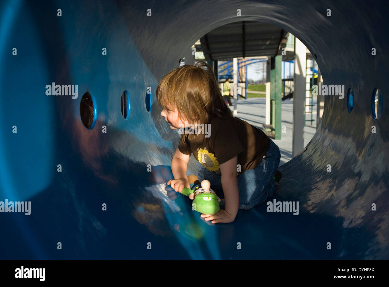 Tre anni di vecchio ragazzo giocare nel parco giochi Tunnel a Waterfront Park a Louisville, Kentucky Foto Stock