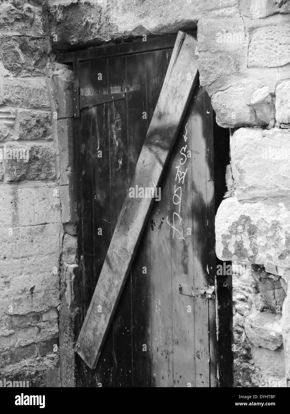 Abbandonata / beni abbandonati con grossolanamente porta sbarrata per prevenire atti di vandalismo, Newcastle upon Tyne, Regno Unito - B&W, bianco e nero Foto Stock