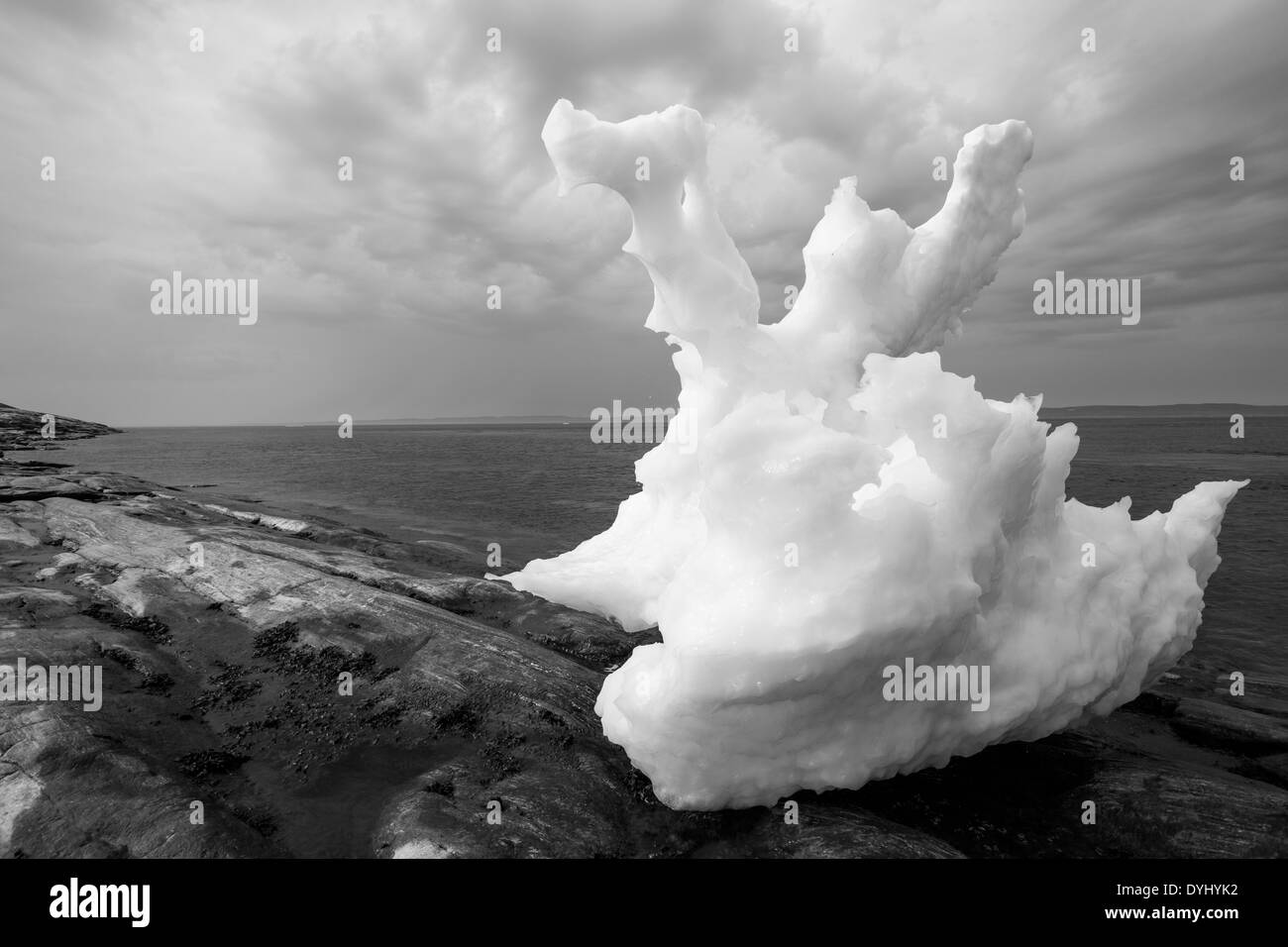 In Canada. Nunavut Territorio, Ukkusiksalik National Park, fusione iceberg collegato a massa a bassa marea lungo la baia di scommessa sul pomeriggio estivo Foto Stock