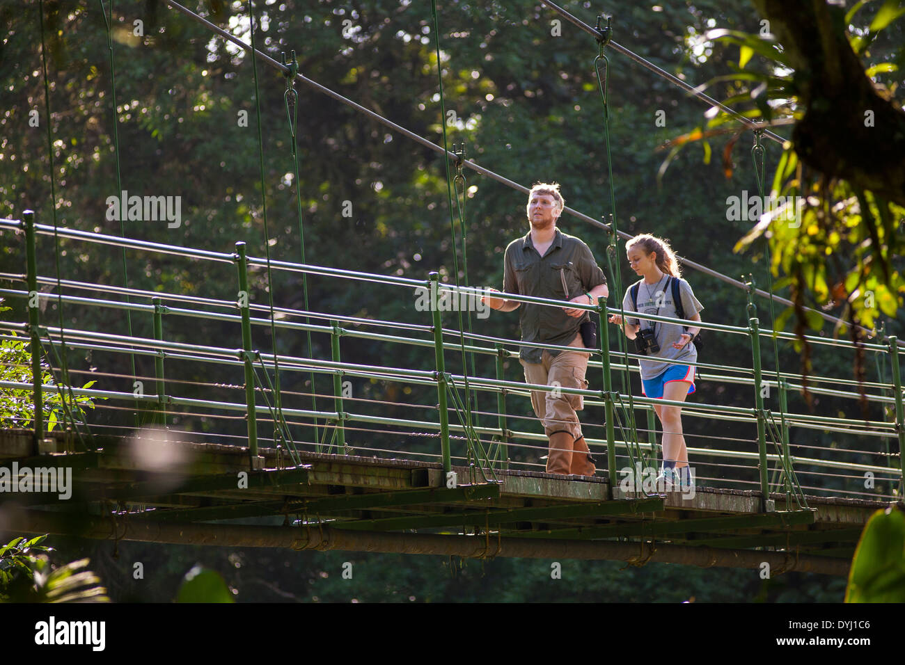 Due studenti a piedi attraversando un ponte su un percorso guidato tour della natura a La Selva La stazione biologica in Sarapiqui de Viejo, Costa Rica Foto Stock
