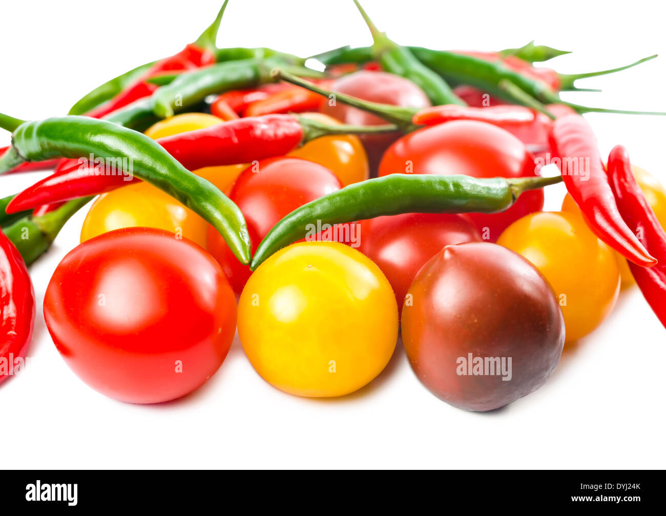 Fresche e mature, di colore rosso giallo, nero pomodori ciliegia e pepe è isolato su sfondo bianco Foto Stock