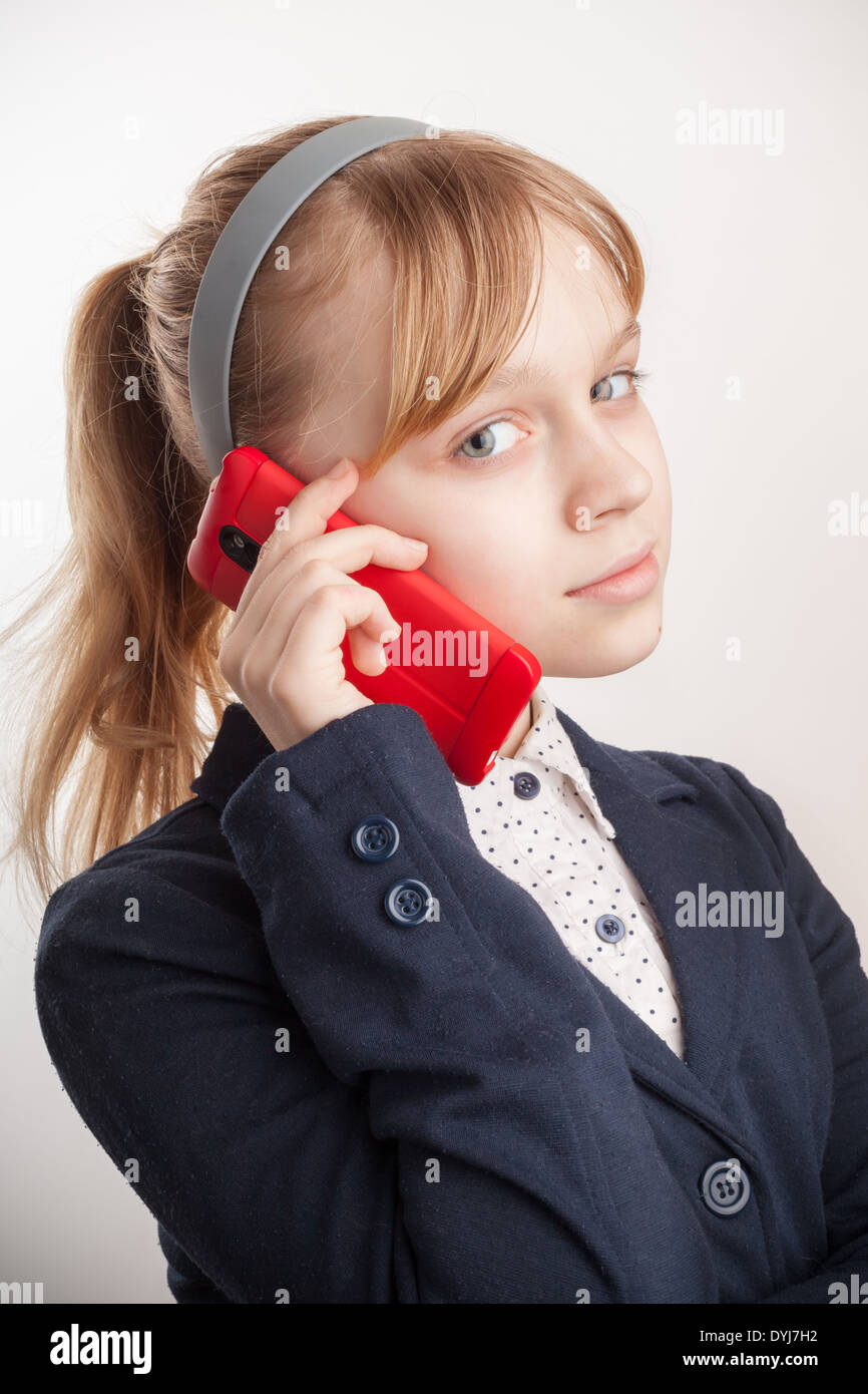 Bionda scolaretta caucasica chiamando dal telefono cellulare su sfondo bianco Foto Stock