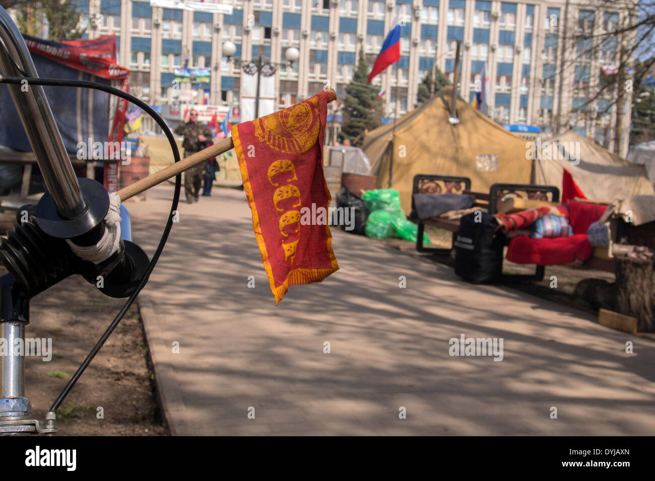 Lugansk, Ucraina. Il 19 aprile 2014. La bandiera rossa dell'URSS iscrizione fissato al manubrio di una bicicletta in una tenda camp di fronte ucraino ufficio regionale del servizio di sicurezza in Luhansk --- armati pro-russo militanti rintanato in ucraino ufficio regionale del servizio di sicurezza in Luhansk e ha rifiutato di rinunciare alle loro braccia e si è impegnato a combattere eventuali sforzi da parte dello stato per rimuoverli. Credito: Igor Golovnov/Alamy Live News Foto Stock